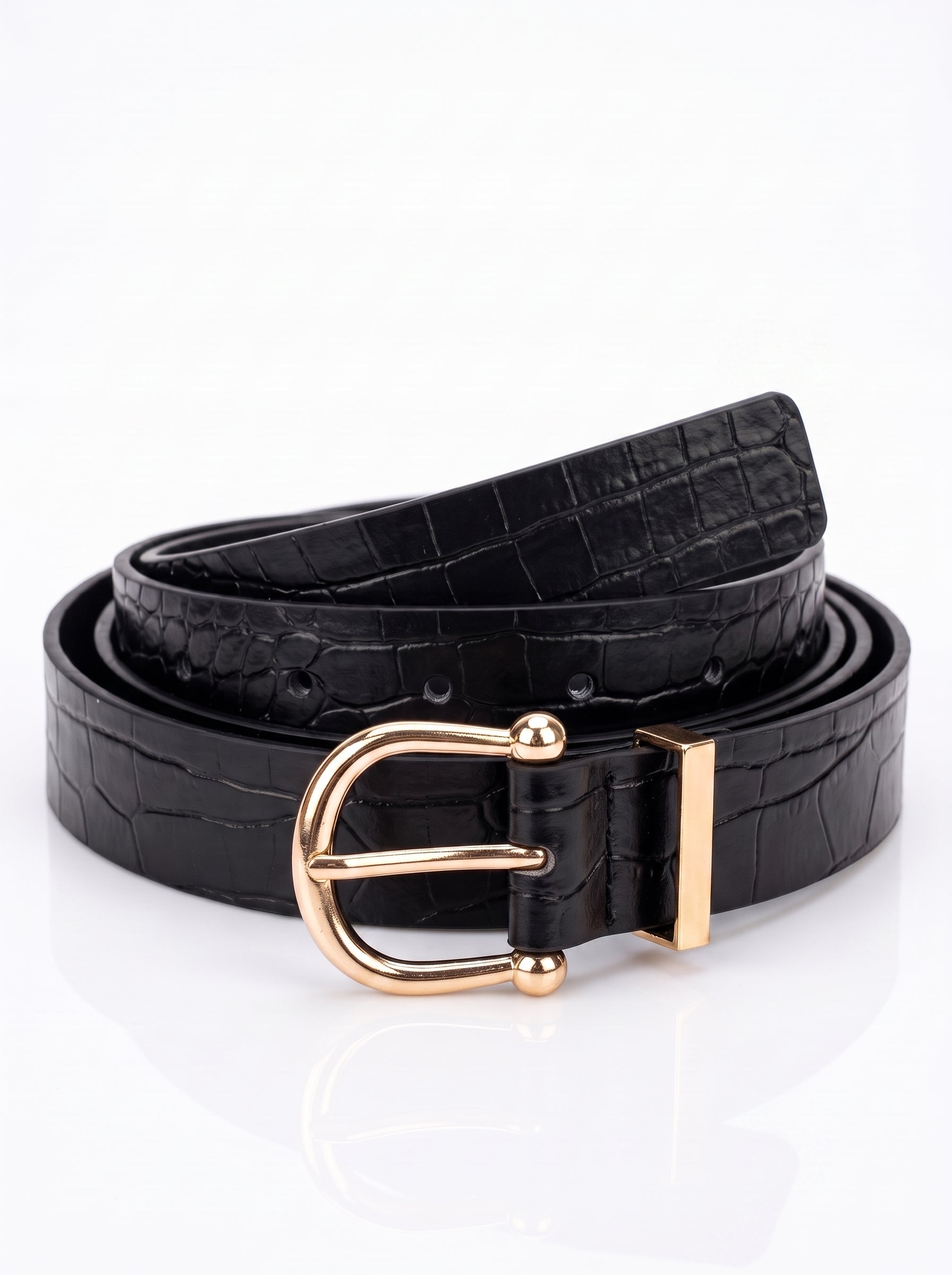 A black crocodile-embossed leather belt with a polished gold-tone metal buckle, coiled on a reflective white surface.