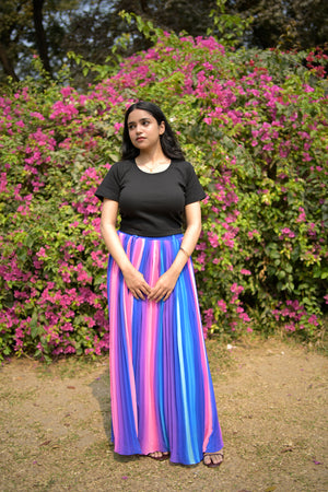 Woman in a colorful dress standing among pink flowers