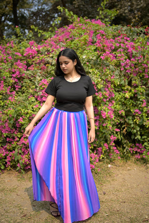 Person wearing a colorful striped dress standing in front of pink flowers trendy buzz