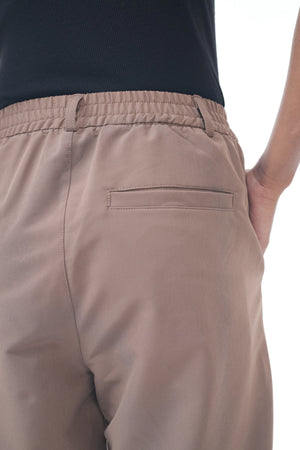 Brown pants worn by a person on a white background