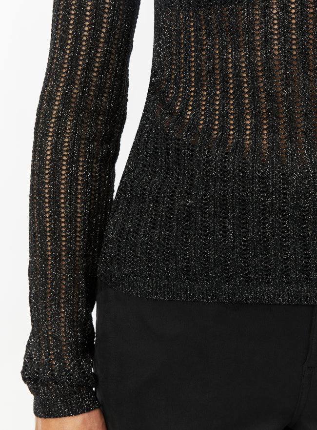 Woman wearing a black textured mesh top which is glittery for party use. trendy buzz bd.