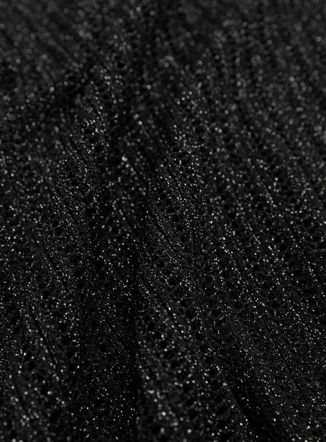 Woman wearing a black textured mesh top which is glittery for party use. trendy buzz bd.