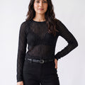 Woman wearing a black textured mesh top which is glittery for party use. trendy buzz bd.