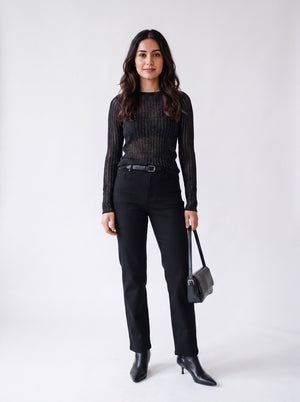 Woman wearing a black textured mesh top which is glittery for party use. trendy buzz bd.