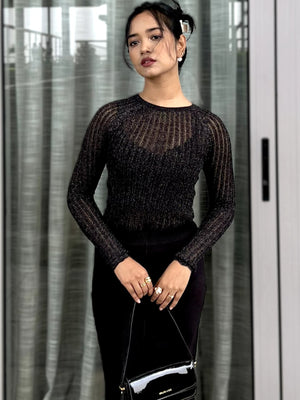 Woman wearing a black textured mesh top which is glittery for party use. trendy buzz