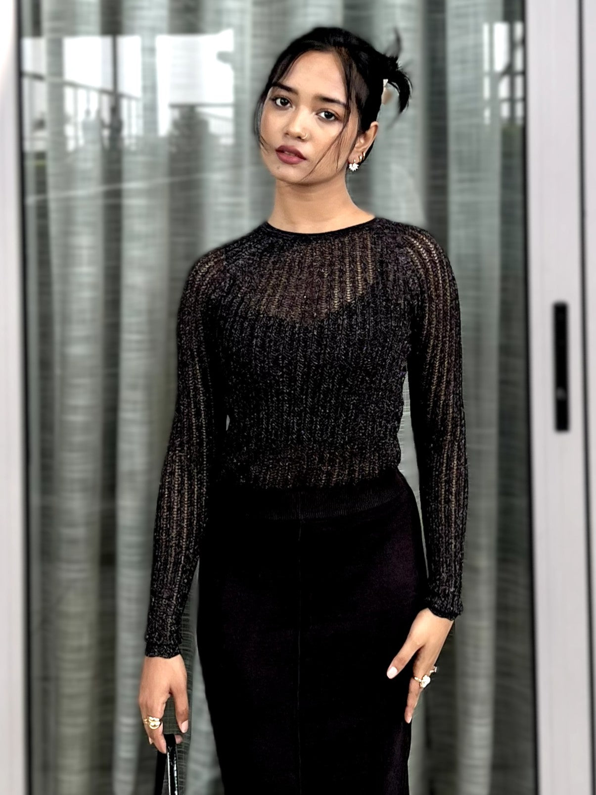 Woman wearing a black textured mesh top which is glittery for party use. Sheer Top. Trendy Buzz.