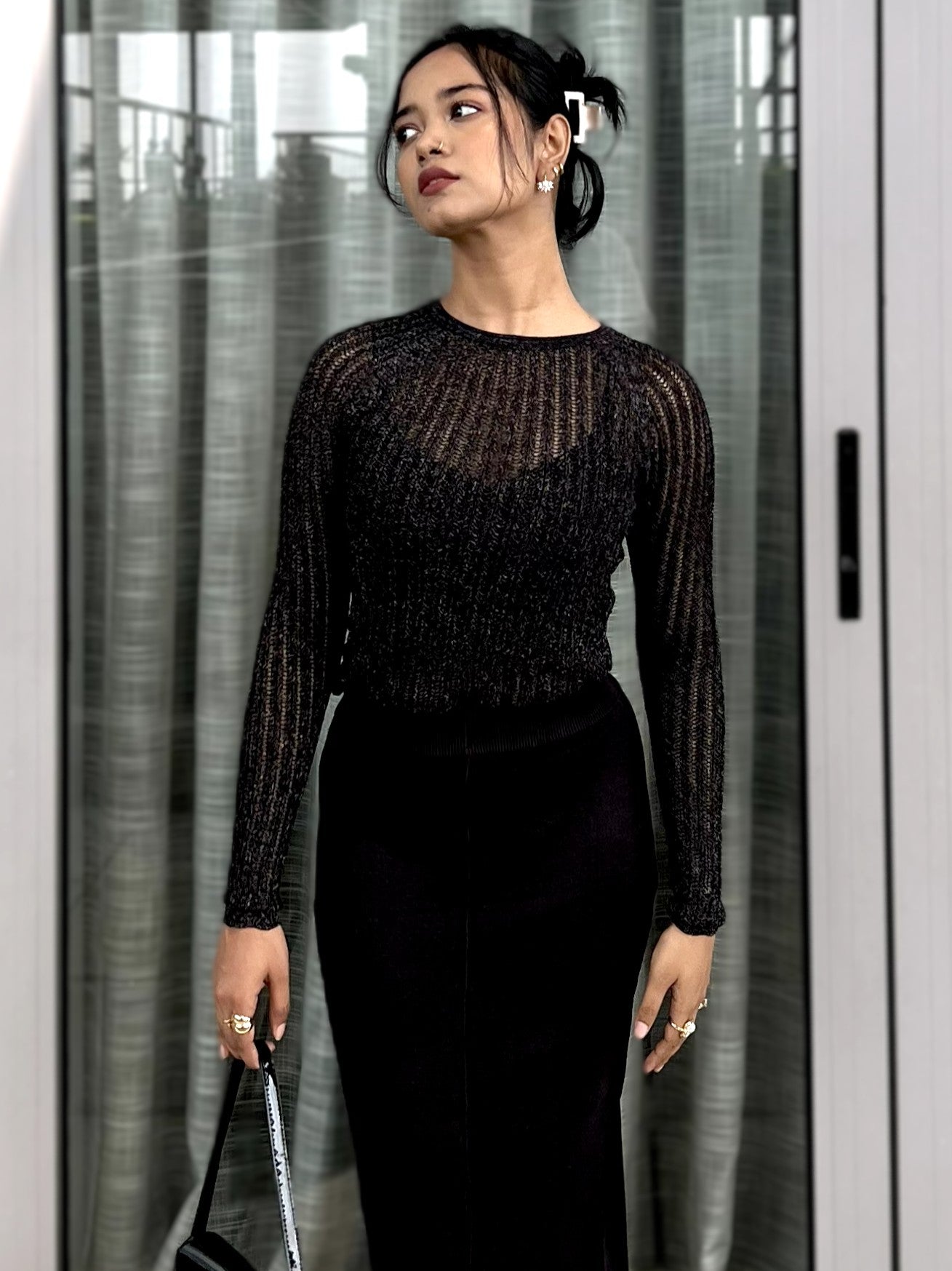 Woman wearing a black textured mesh top which is glittery for party use. Sheer Top. Trendy Buzz.
