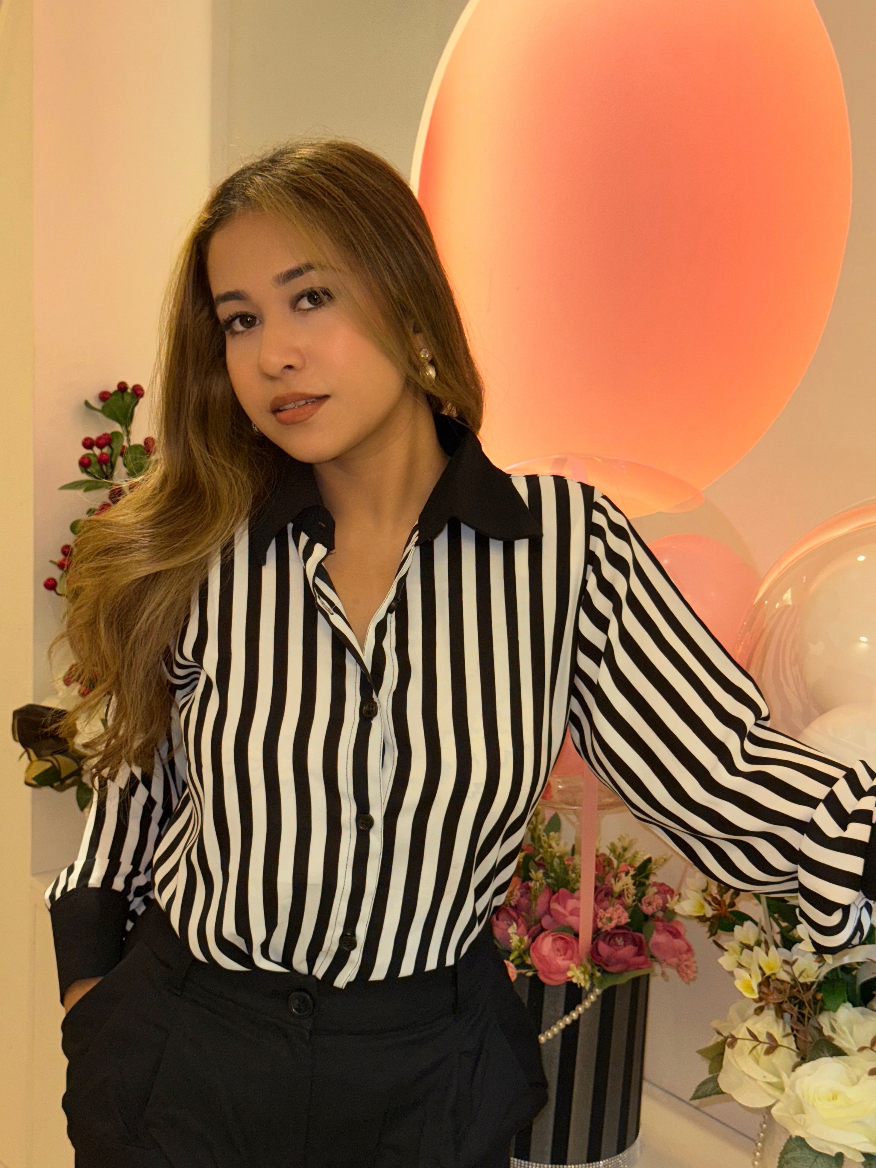 Woman wearing a black and white striped shirt with a blurred background