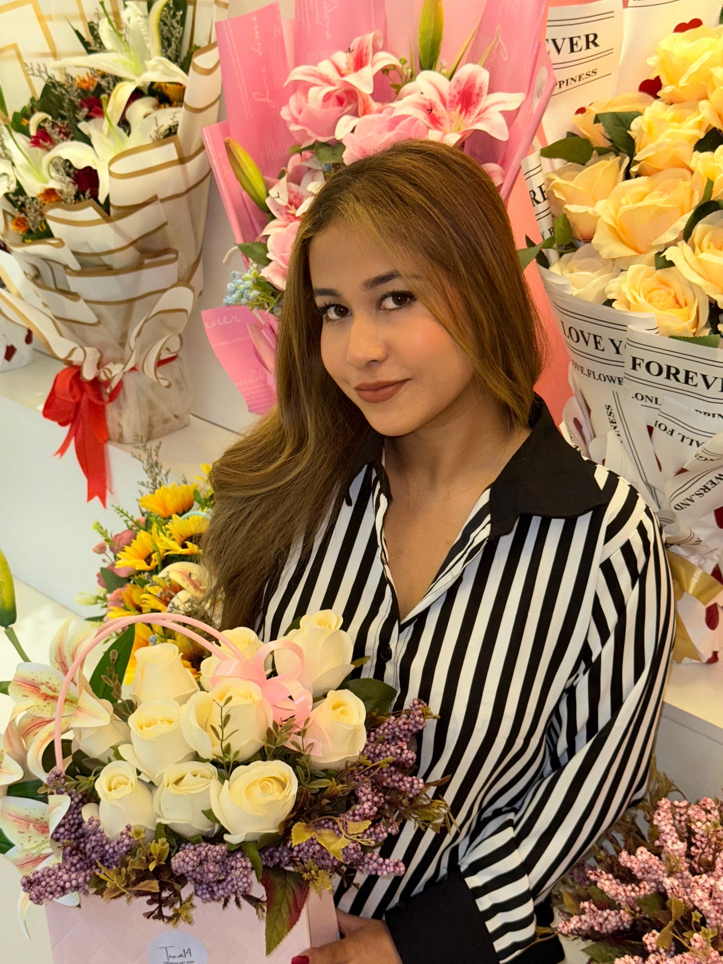 Woman holding a bouquet of flowers surrounded by floral arrangements and decorative items wering Trendy Buzz Black & White Stripe Formal Shirt