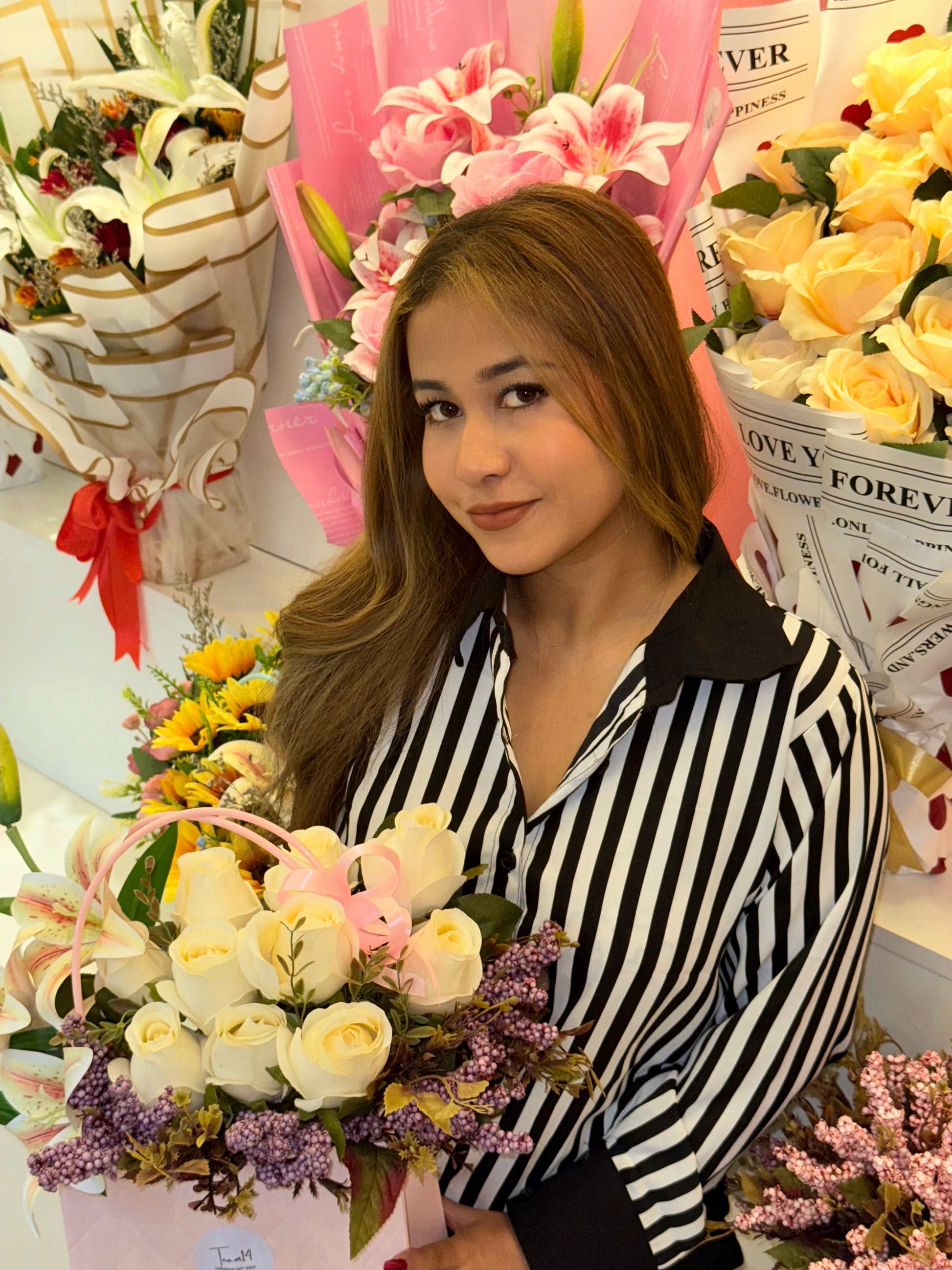 Woman holding a bouquet of flowers surrounded by floral arrangements and decorative items wering Trendy Buzz Black & White Stripe Formal Shirt