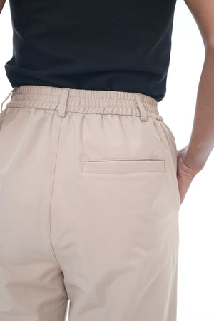 Beige pants with a navy shirt on a white background