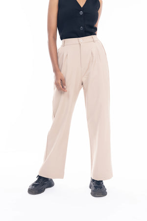Person wearing beige pants and a black top on a white background