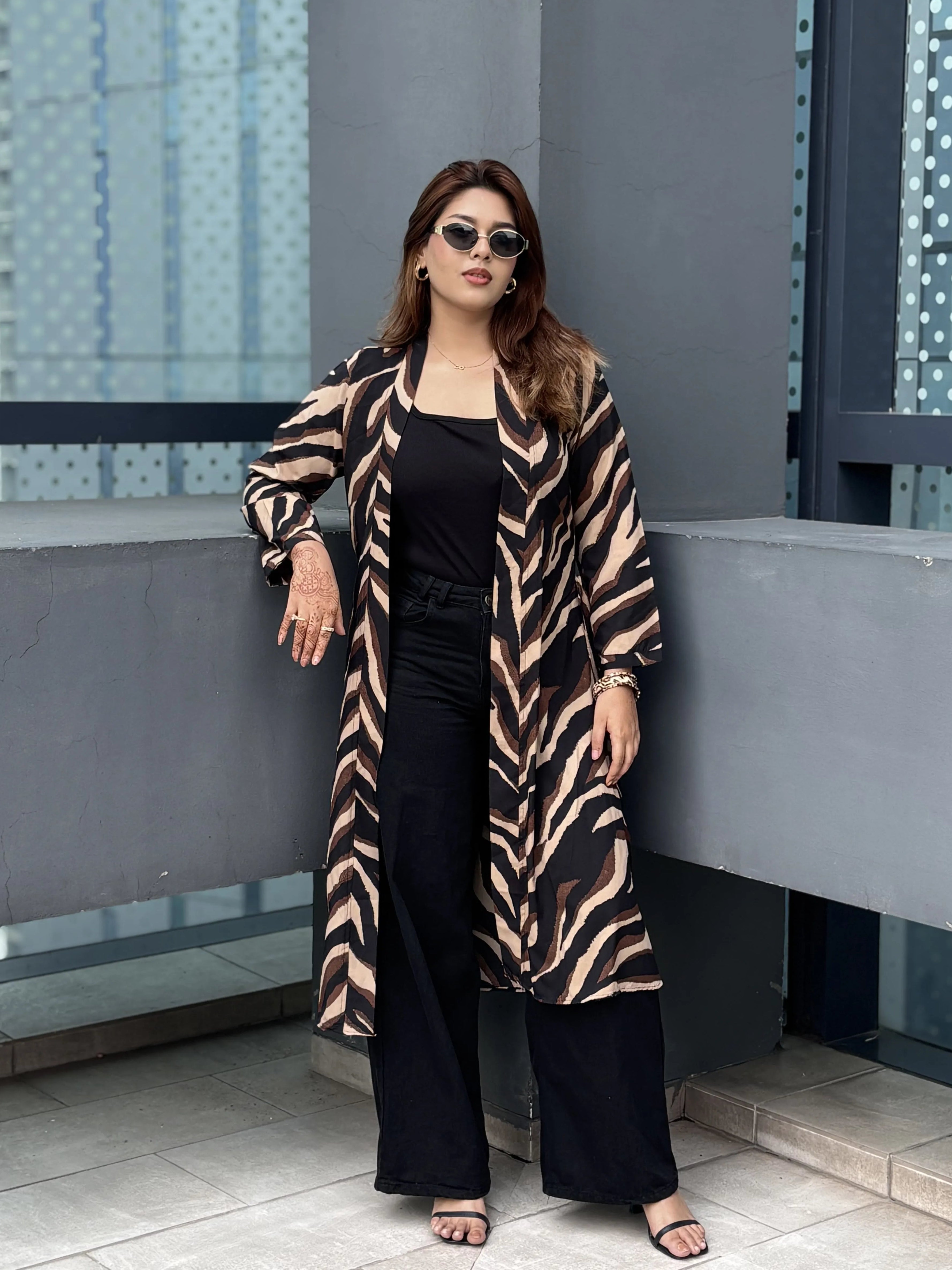 Woman wearing a zebra print Shrug and black outfit in an urban setting