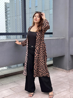 Woman wearing a patterned shrug standing on a rooftop with cityscape background