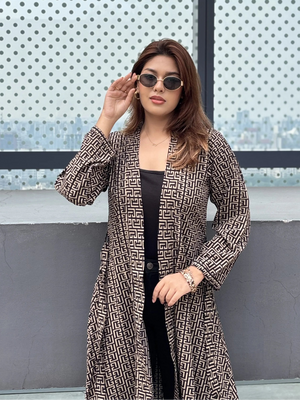 Woman wearing a patterned Shrug and sunglasses against a cityscape background