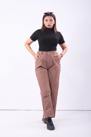 Woman wearing a black top and brown pants on a white background
