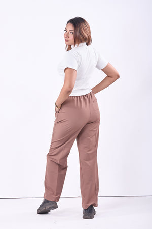 Woman wearing a white shirt and brown pants on a white background