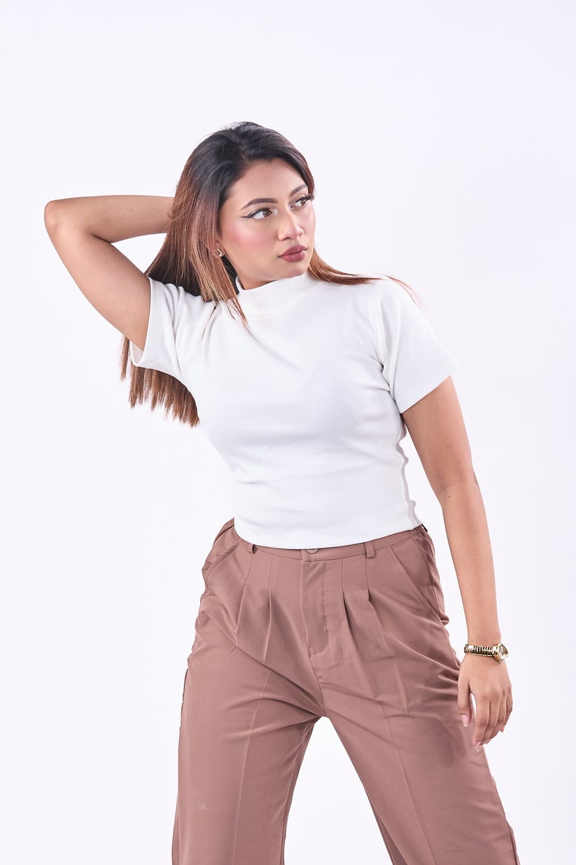 Woman wearing a white top and brown pants on a white background
