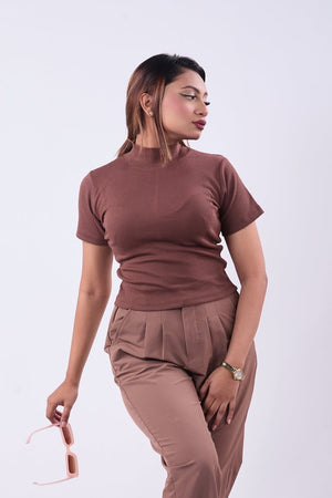 Woman wearing a brown outfit with a top and flared pants on a white background