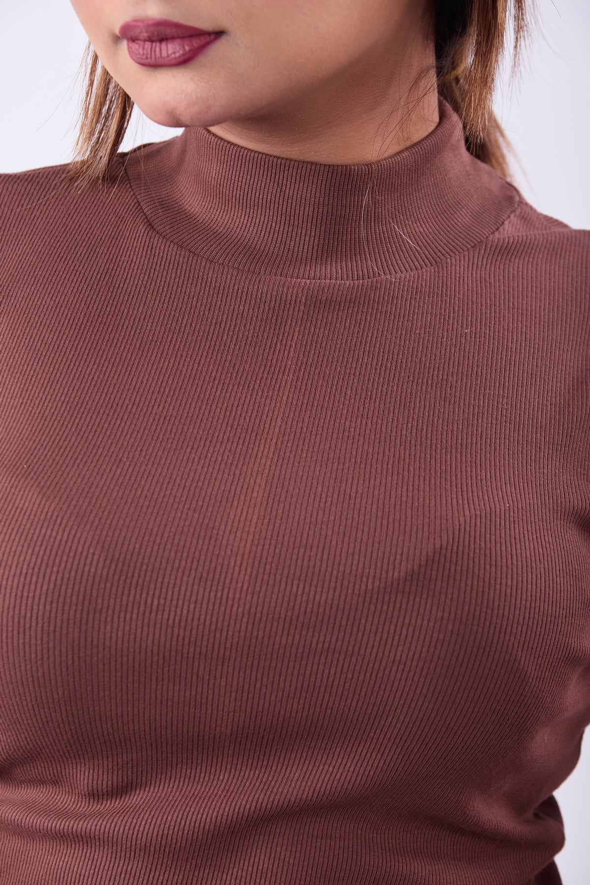 Close-up of a brown ribbed sweater worn by a person.