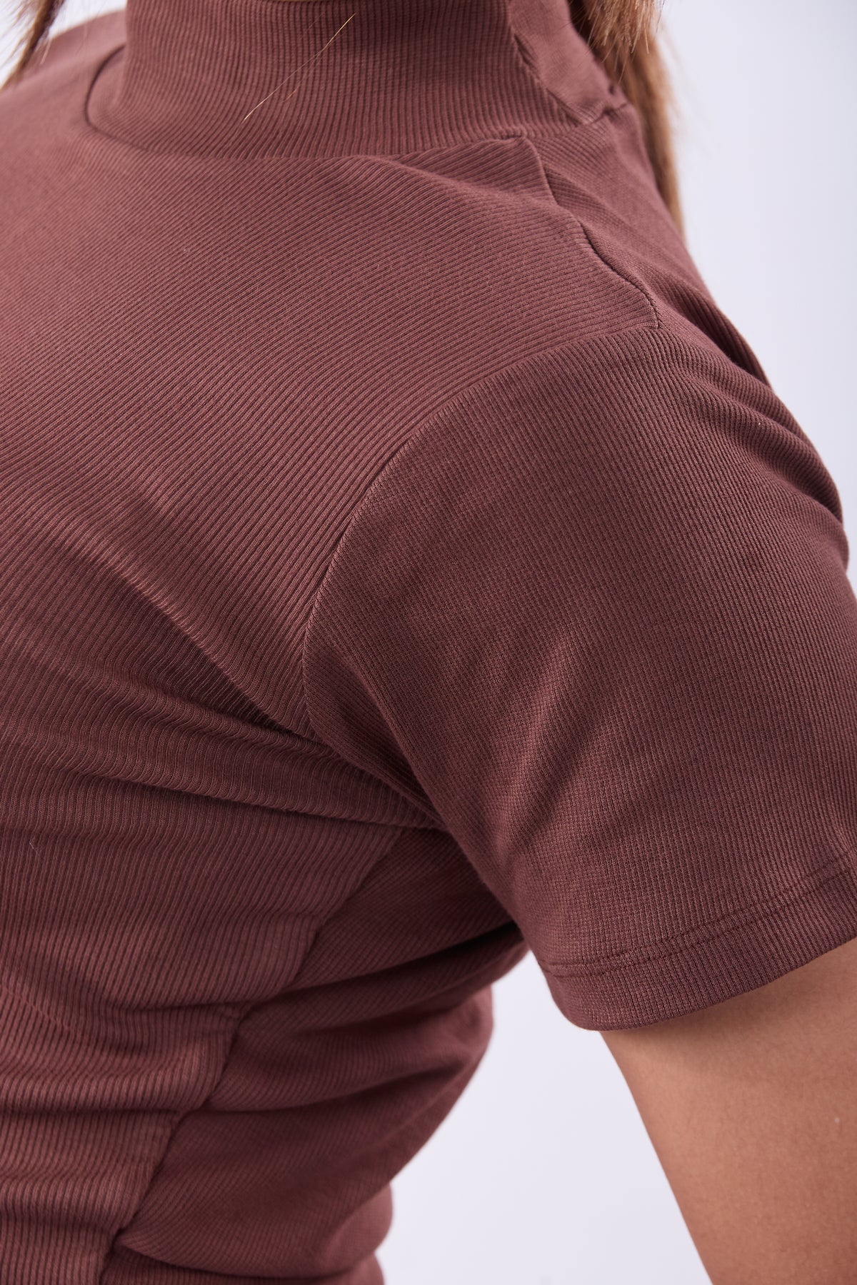 Brown short-sleeve shirt worn by a person on a white background