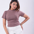 Woman wearing a mauve turtleneck and white pants on a white background