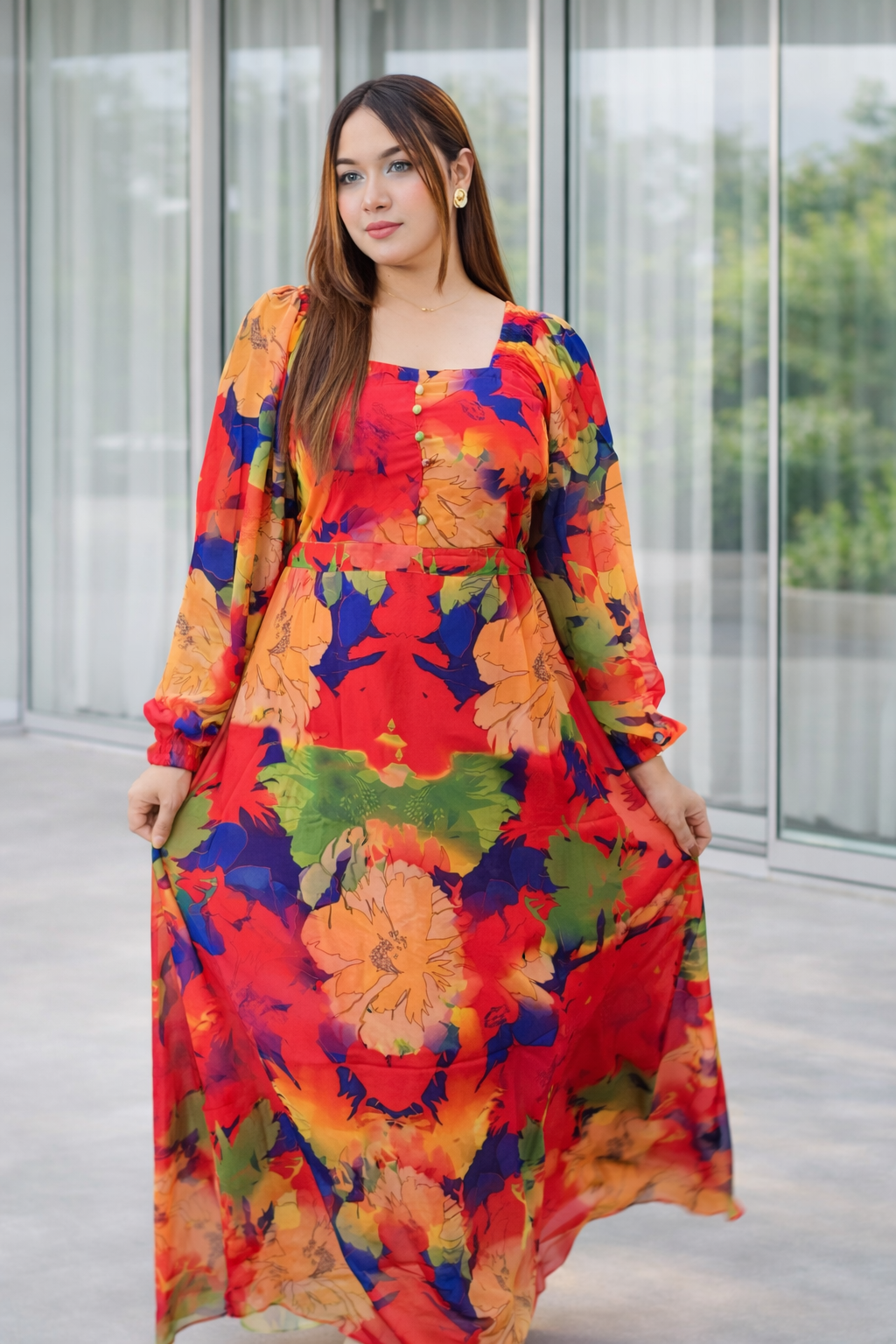 Woman wearing a colorful floral dress standing in front of a glass wall. Trendy buzz.