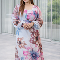 Woman wearing a floral dress standing in a modern indoor setting.