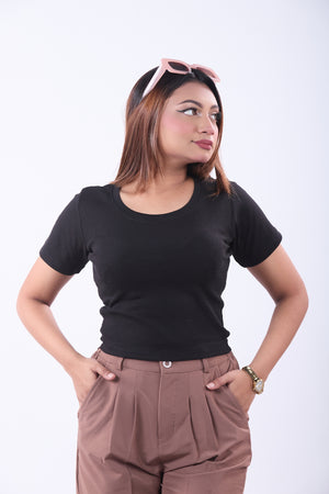 Woman wearing a black t-shirt and brown pants on a white background