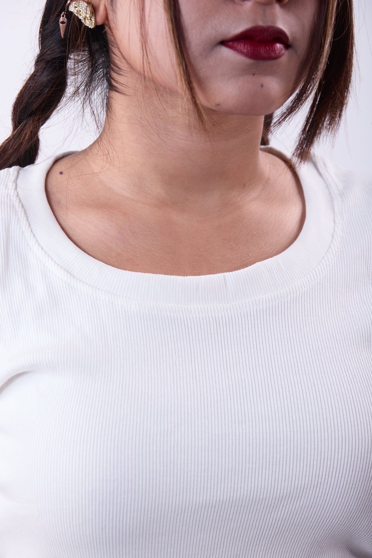 Close-up of a person wearing a white top with a blurred background