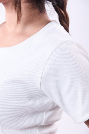 Close-up of a person wearing a white blouse with short sleeves.