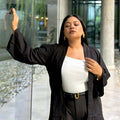Woman wearing a premium solid black crinkle crepe kimono with textured popcorn fabric