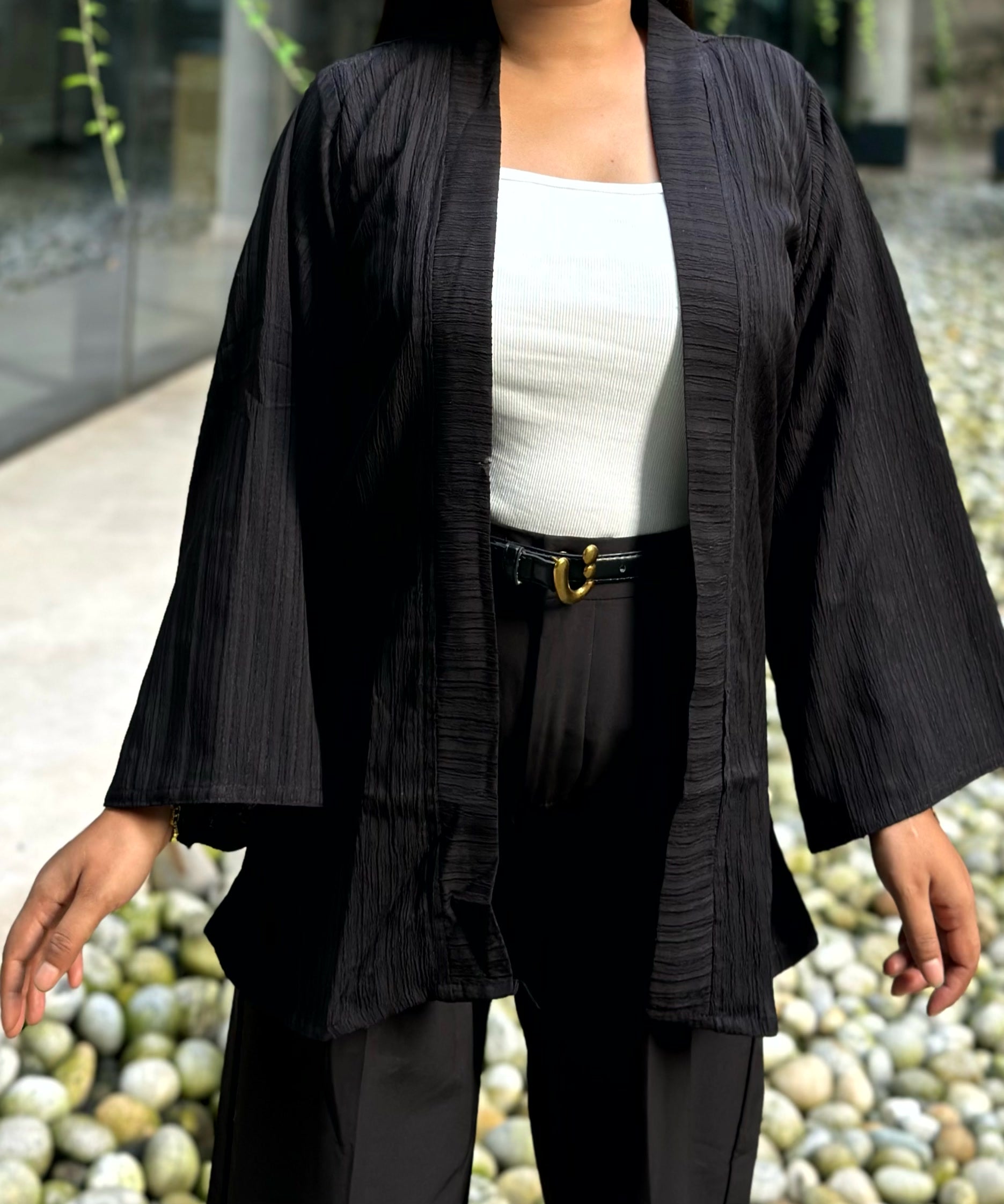 Woman wearing a premium solid black crinkle crepe kimono with textured popcorn fabric