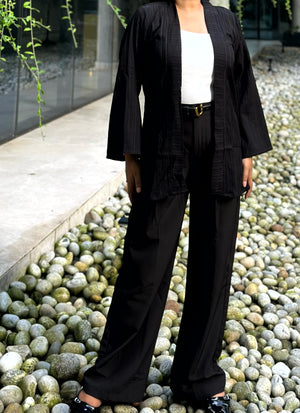 Woman wearing a premium solid black crinkle crepe kimono with textured popcorn fabric