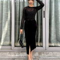 Woman in a black outfit standing in front of a glass door.