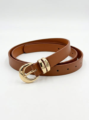 A brown leather belt with a polished gold-tone buckle, shown coiled on a clean white background.