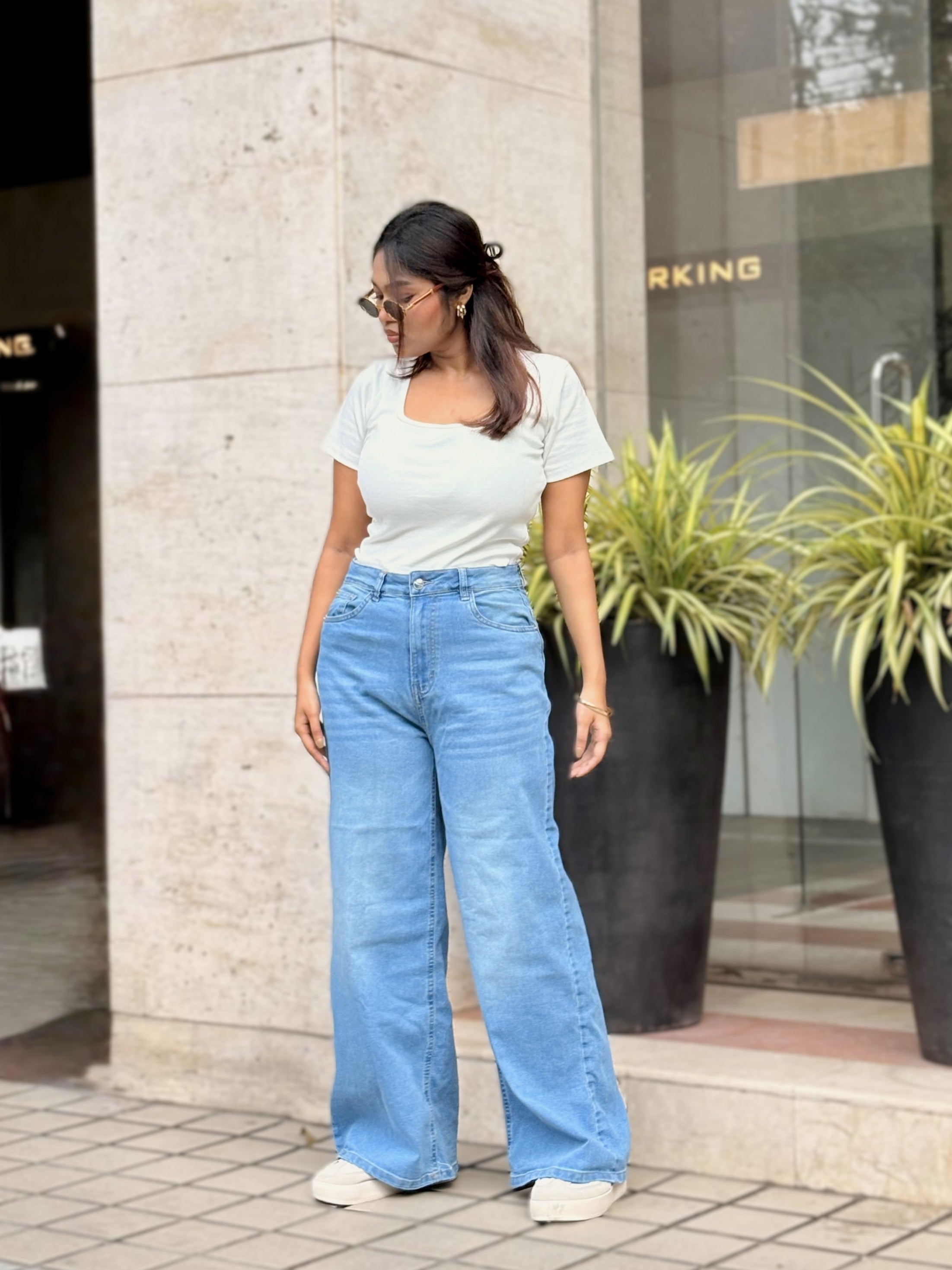 Women's Trendy Wide Leg Jeans in Light Blue with high-waist fit, front and back pockets, belt loops and relaxed wide-leg silhouette by Trendy Buzz.