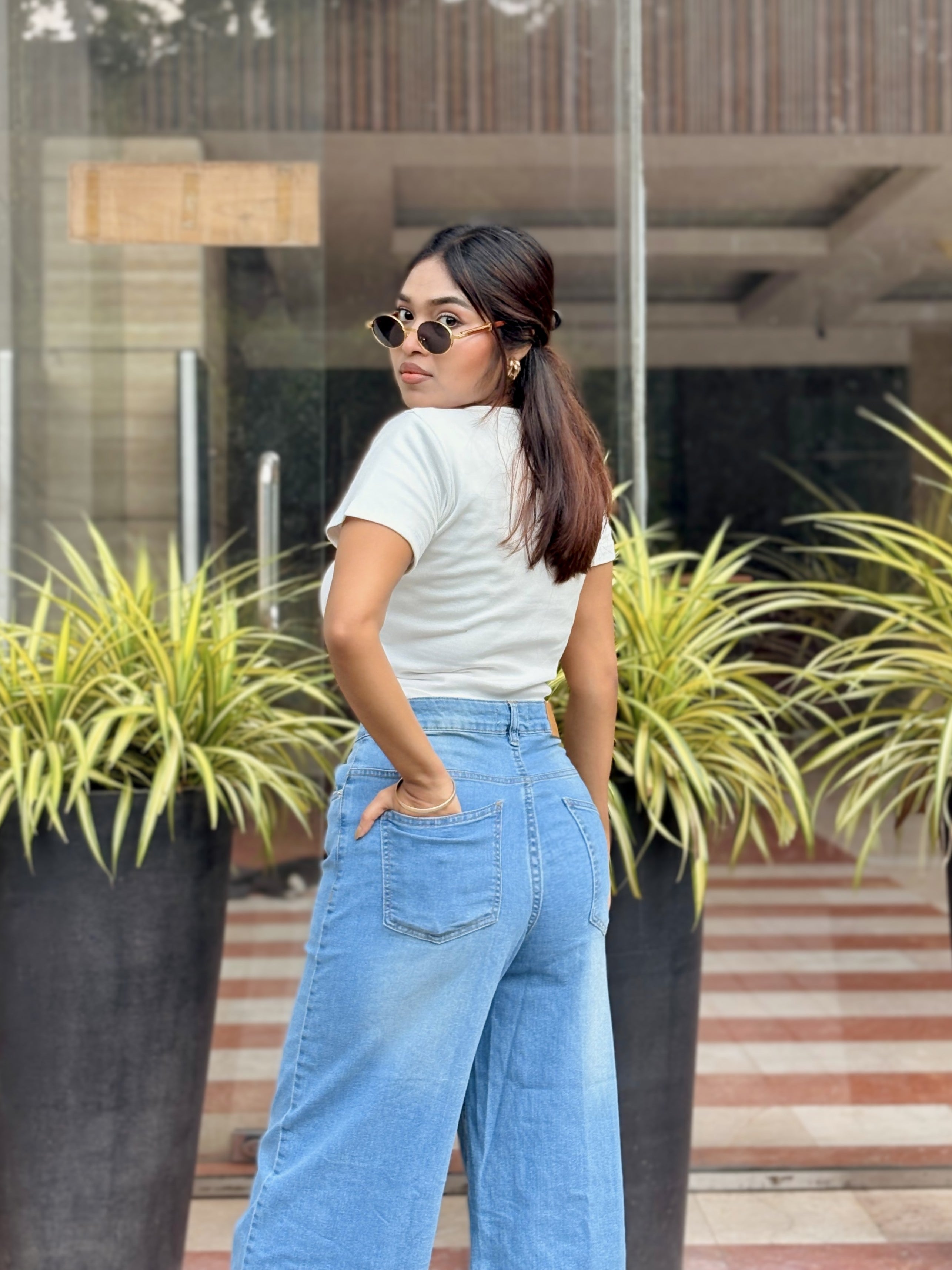 Women's Trendy Wide Leg Jeans in Light Blue with high-waist fit, front and back pockets, belt loops and relaxed wide-leg silhouette by Trendy Buzz.