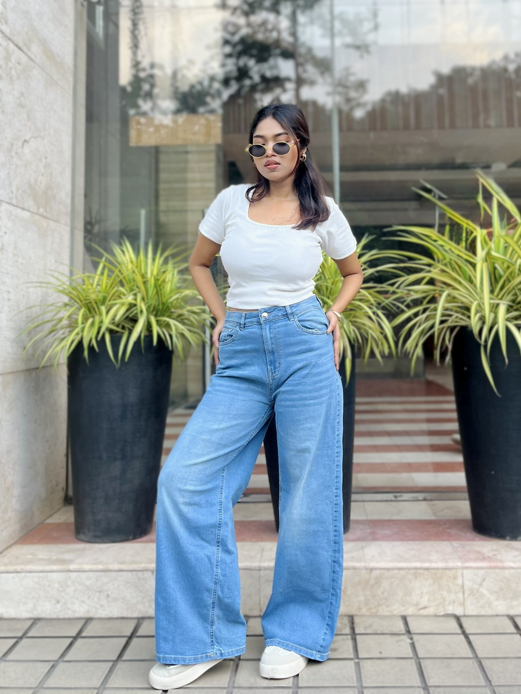 Women's Trendy Wide Leg Jeans in Light Blue with high-waist fit, front and back pockets, belt loops and relaxed wide-leg silhouette by Trendy Buzz.