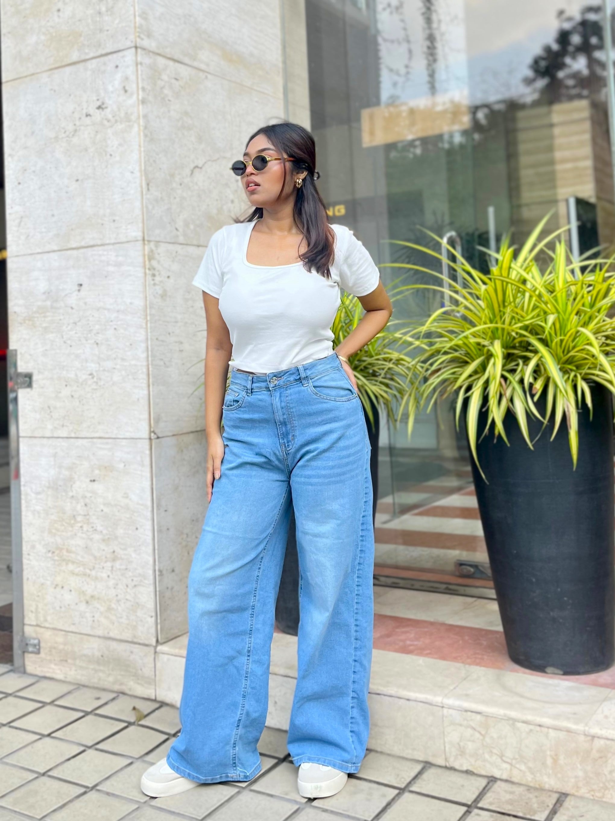 Women's Trendy Wide Leg Jeans in Light Blue with high-waist fit, front and back pockets, belt loops and relaxed wide-leg silhouette by Trendy Buzz.