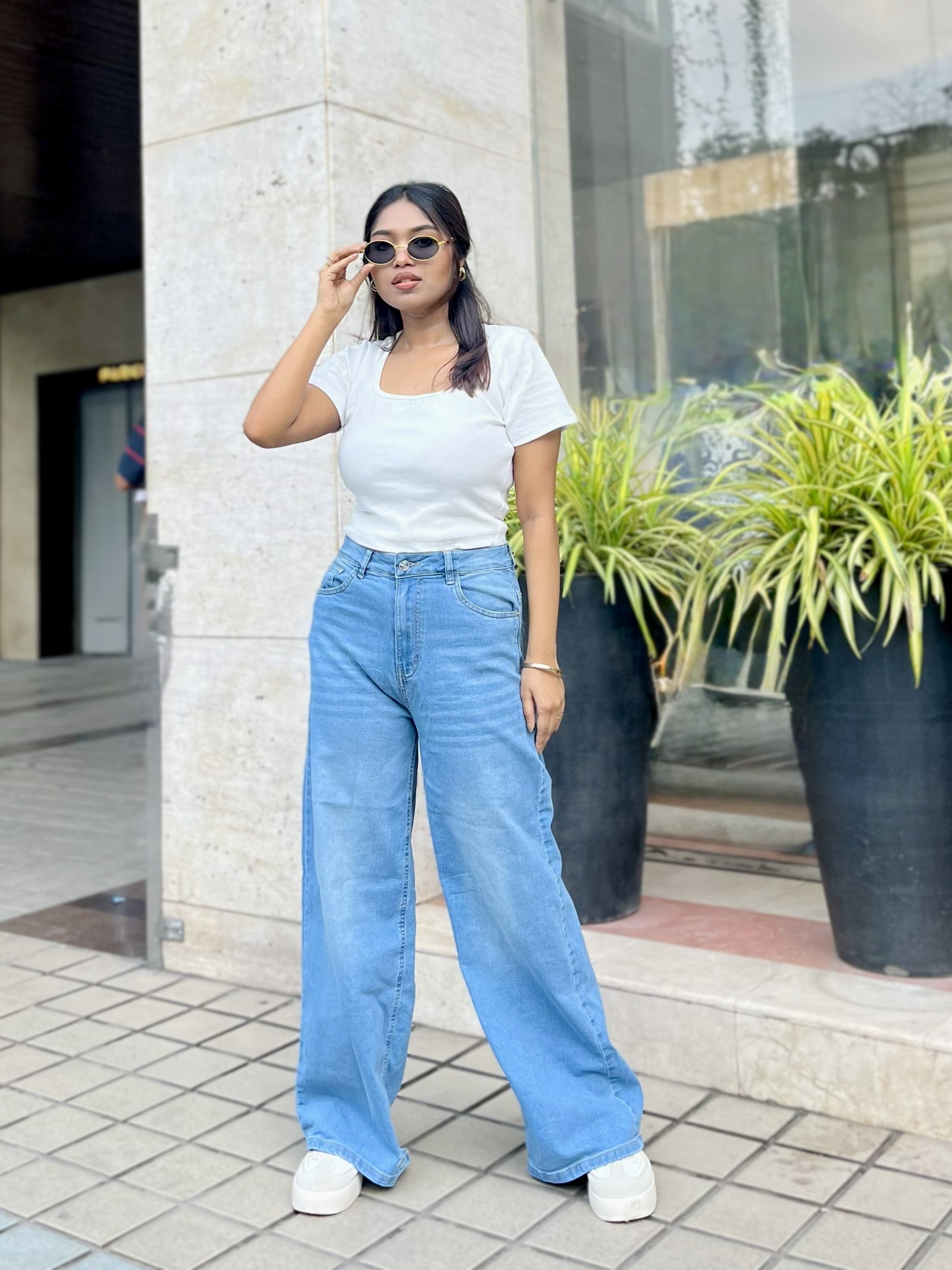 Women's Trendy Wide Leg Jeans in Light Blue with high-waist fit, front and back pockets, belt loops and relaxed wide-leg silhouette by Trendy Buzz.