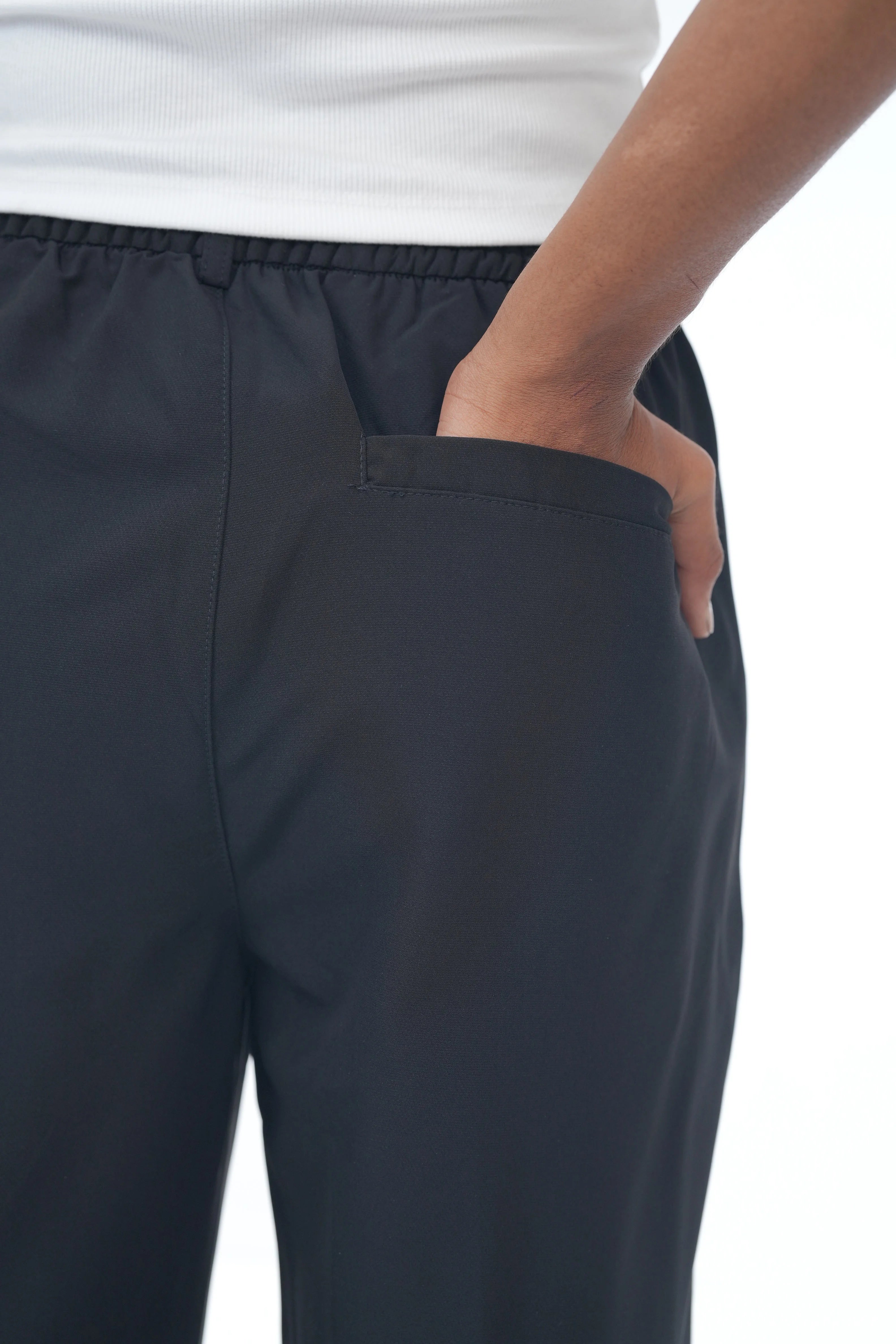 Navy blue pants worn by a person on a white background