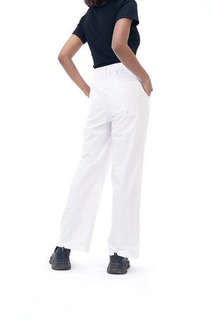 Person wearing a navy top and white pants on a white background