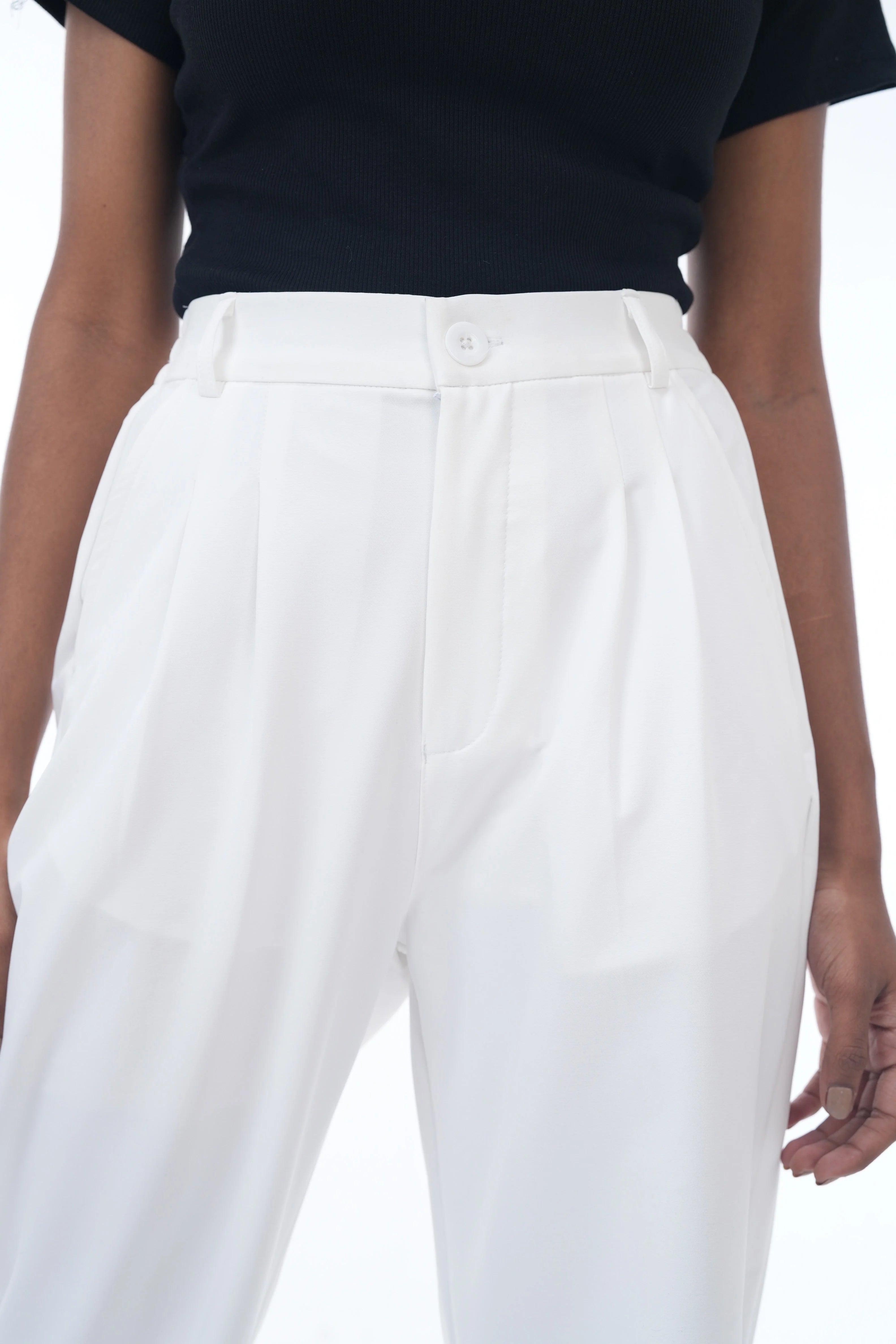 White pants worn by a person on a white background