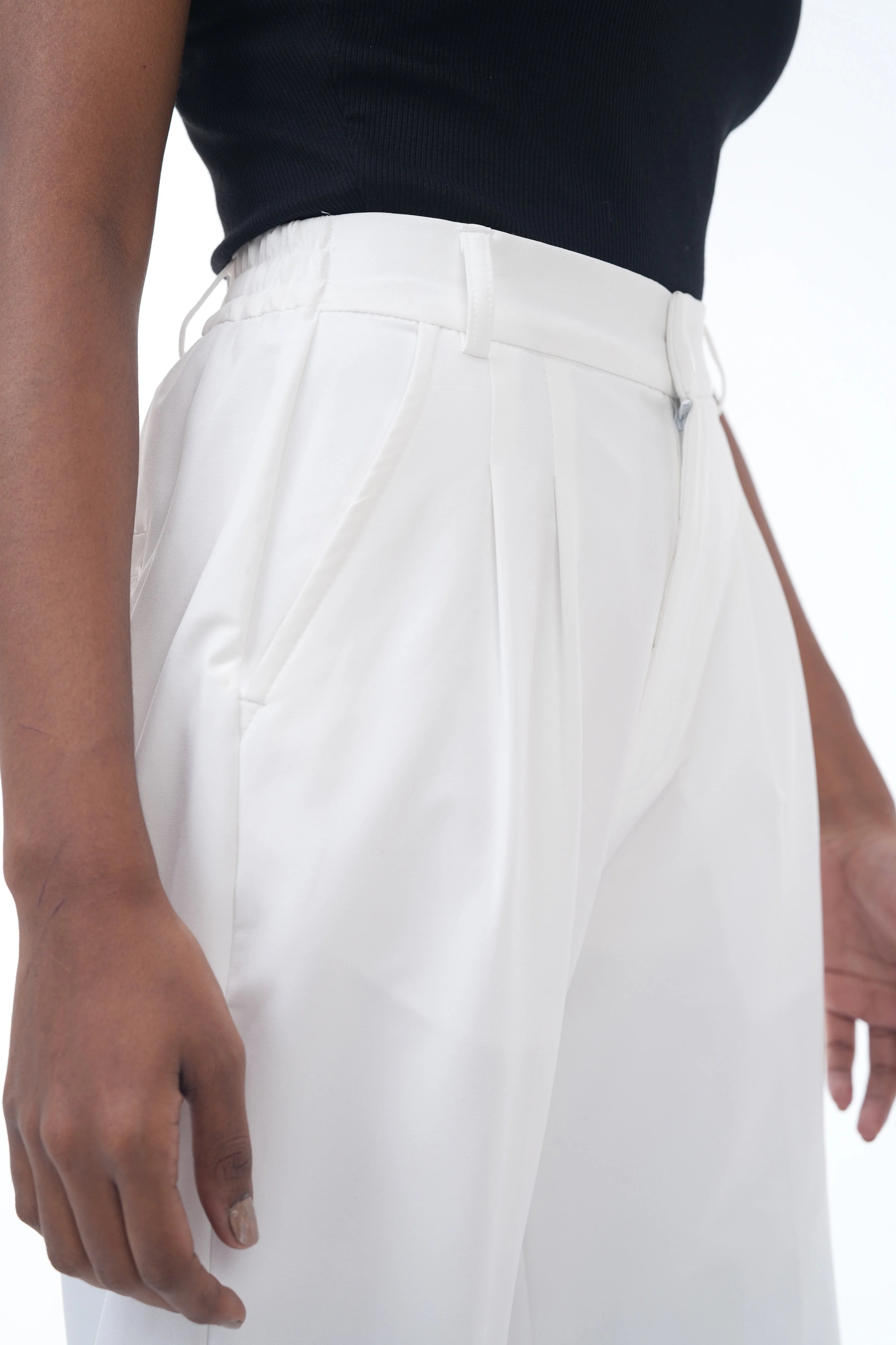 White pants worn by a person on a white background