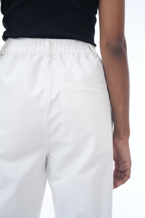 White pants worn by a person on a white background