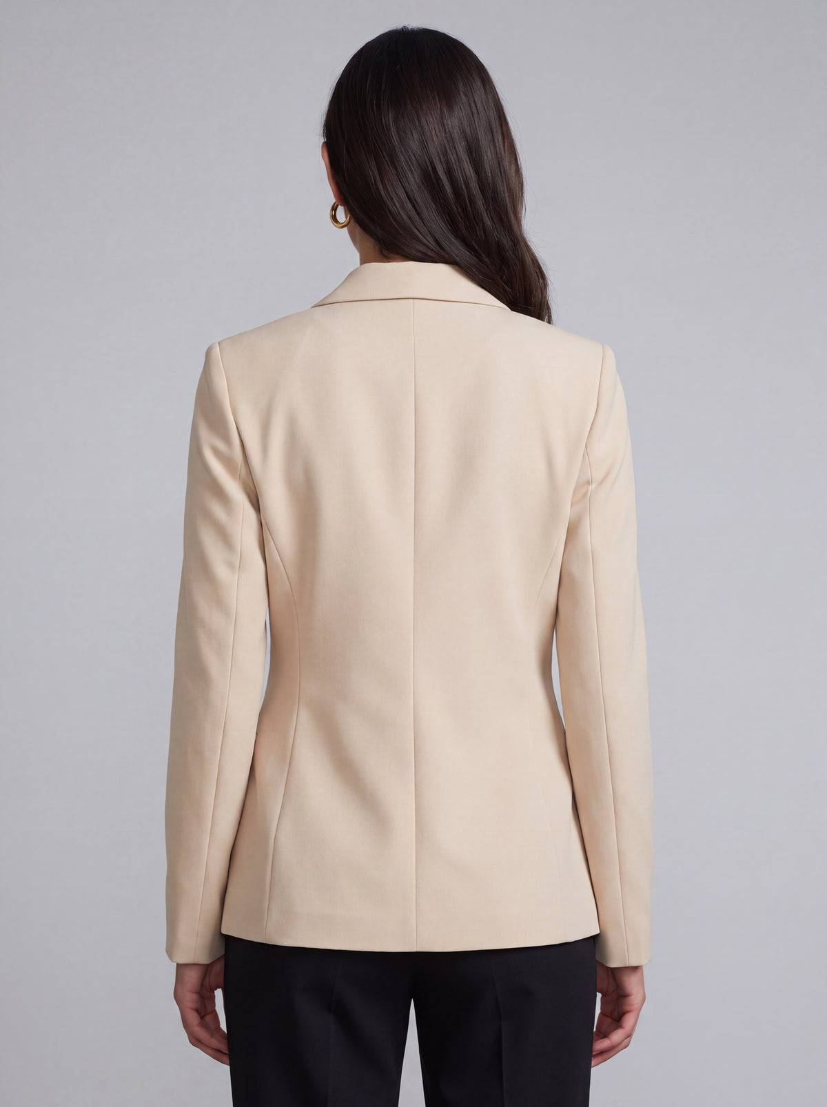 A woman wearing light beige slim-fit formal blazer with notched lapels, front flap pockets, and a single-button closure, styled over a black top and dark trousers. Trendy Buzz BD.